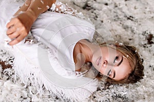 Young beautiful bride in boho style and white feathers