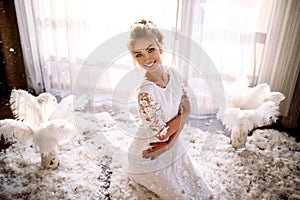 Young beautiful bride in boho style and white feathers