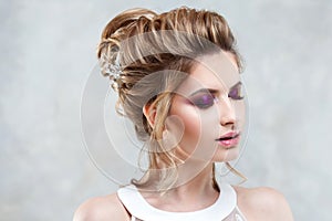 Young beautiful bride with an elegant high hairdo. Wedding hairstyle with the accessory in her hair