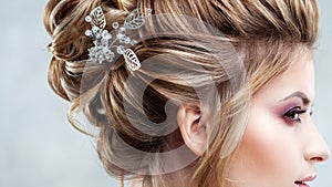 Young beautiful bride with an elegant high hairdo. Wedding hairstyle with the accessory in her hair