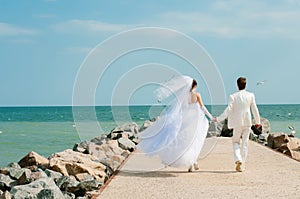 Young and beautiful bride and groom on the beach