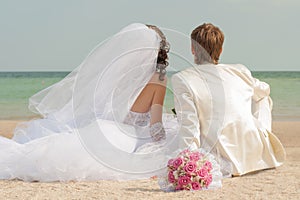 Young and beautiful bride and groom on the beach photo