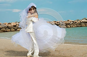 Young and beautiful bride and groom on the beach