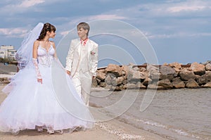 Young and beautiful bride and groom on the beach