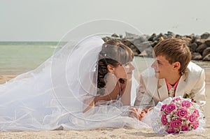 Young and beautiful bride and groom on the beach