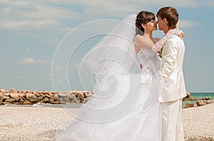 Young and beautiful bride and groom on the beach