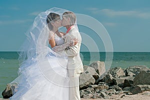 Young and beautiful bride and groom on the beach