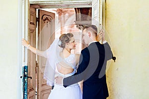 Young beautiful bride and groom near old door