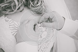 Young beautiful bride and male hands buttoning wedding dress