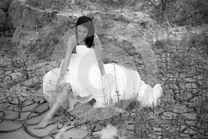 Young beautiful bride sitting in desert