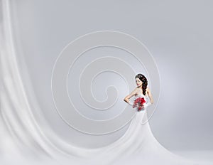 Young and beautiful bride standing with a flower bouquet