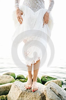 Young beautiful bride in wedding dress near sea