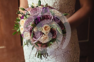 Young beautiful bride in white dress holding wedding bouquet, bouquet of bride from rose cream spray, rose bush, rose purple Memor