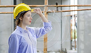 Young beautiful brown hair woman holding construction helmet while looking at the progress of real estate projects. The