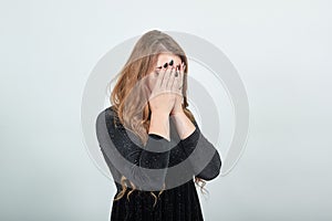 Girl brown haired in black dress over isolated white background shows emotions