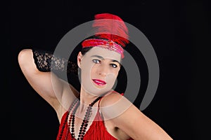 Young beautiful brunette in 1920 style attire red dress and a fe