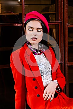 beautiful brunette girl in a red suit, white shirt and red beret