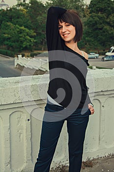 Young beautiful brunette girl standing on the bridge