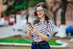 Young beautiful brunette girl in sunglasses listen the music in your smartphone,