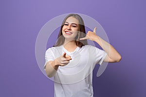 Young beautiful brunette girl wearing white t shirt standing over purple background smiling doing talking on the telephone gesture