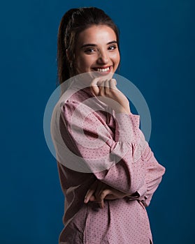 Joven hermoso morena en rosa un suéter azul sobre el mimoso apariencia muy dulce posando en estudio 