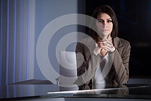 Young beautiful brunette television announcer at studio during live broadcasting.Female TV director at editor in studio.