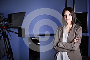 Young beautiful brunette television announcer at studio during live broadcasting.Female TV director at editor in studio.