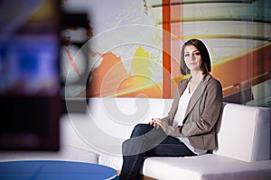 Young beautiful brunette television announcer at studio during live broadcasting.Female TV director at editor in studio.