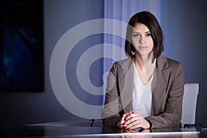 Young beautiful brunette television announcer at studio during live broadcasting.Female TV director at editor in studio. photo