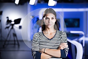 Young beautiful brunette television announcer at studio standing next to the camera.TV director at editor in studio