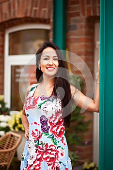 Young beautiful brunette woman with flowers in her hair and colorful dress. Spanish woman