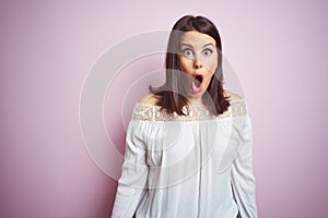 Young beautiful brunette woman over pink isolated background afraid and shocked with surprise expression, fear and excited face