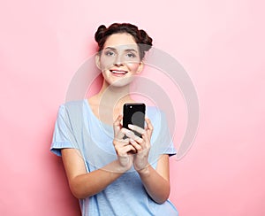 Young beautiful brunette woman with smart phone, looks at the screen and is surprised.