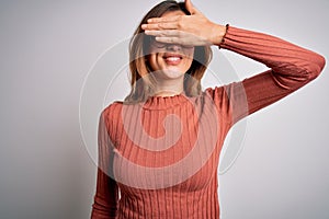 Young beautiful brunette woman wearing casual sweater and glasses over white background smiling and laughing with hand on face