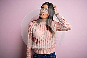 Young beautiful brunette woman wearing casual sweater over isolated pink background confuse and wondering about question