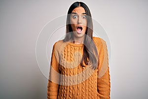 Young beautiful brunette woman wearing casual sweater over isolated white background afraid and shocked with surprise and amazed