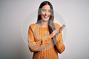 Young beautiful brunette woman wearing casual sweater over isolated white background clapping and applauding happy and joyful,