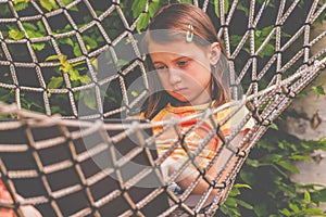 A young beautiful business girl lies in a hammock and working remotely with laptop. Horizontal image