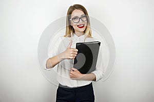 Young beautiful business woman in eyeglasses holding black folder with documents showing ok sign isolated white