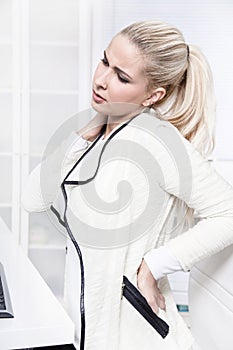 Young beautiful business woman has pains on her back