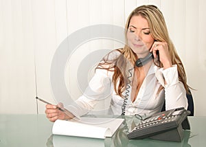 Young beautiful business woman, holding phone and reading notes