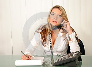 Young beautiful business woman, holding phone and writing on not