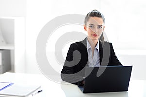 Young beautiful business woman with laptop in the office