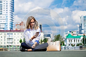 Young beautiful business woman sitting in the city square