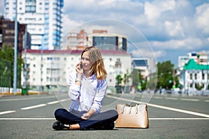 Young beautiful business woman sitting in the city square