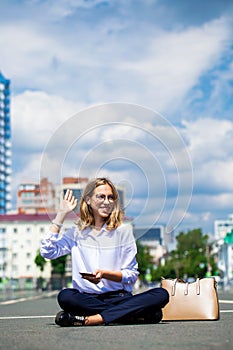 Young beautiful business woman sitting in the city square