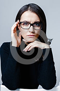 Young beautiful business woman in stylish glasses posing in studio.