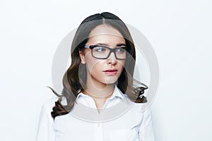 Young beautiful business woman in stylish glasses posing in studio.