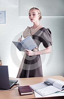 Young beautiful business woman at work with book