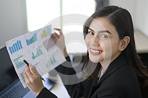 Young beautiful business woman working on laptop with documents in modern office